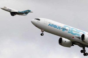 A Large Passenger Jet Flying Through A Cloudy Blue Sky