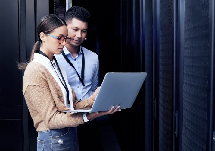 a person standing in front of a laptop a person standing in front of a laptop